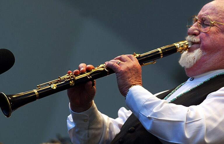 a man playing saxophone clarinet mouthpiece.