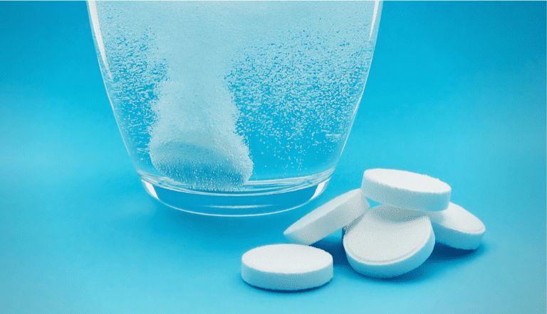 chlorine dioxide tablets and a glass of water in picture.
