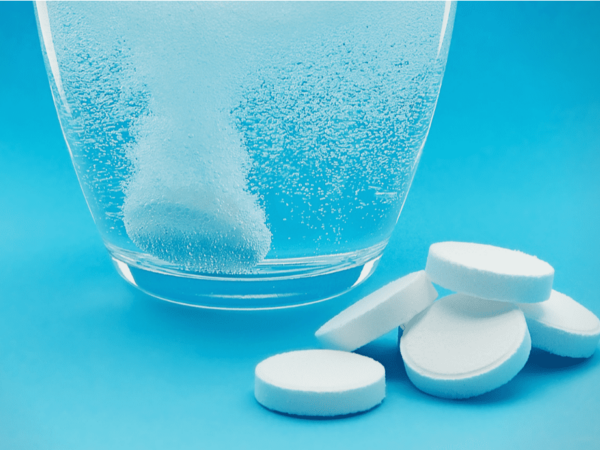 chlorine dioxide tablets and a glass of water in picture.