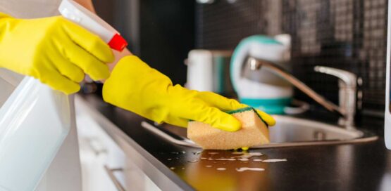 cleaning with sponge near sink in kitchen